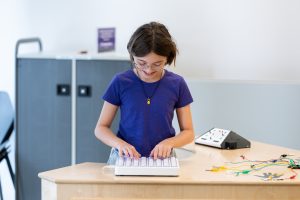 Child with hands on coding surface.